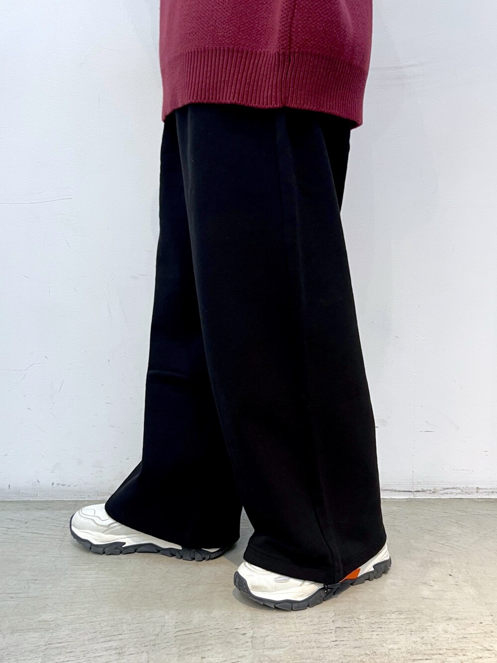 レッド系のニット/セーター、ブラック系のスウェットパンツ、ベージュ系のハンドバッグを着用したレディースの冬コーディネートの4枚目の写真