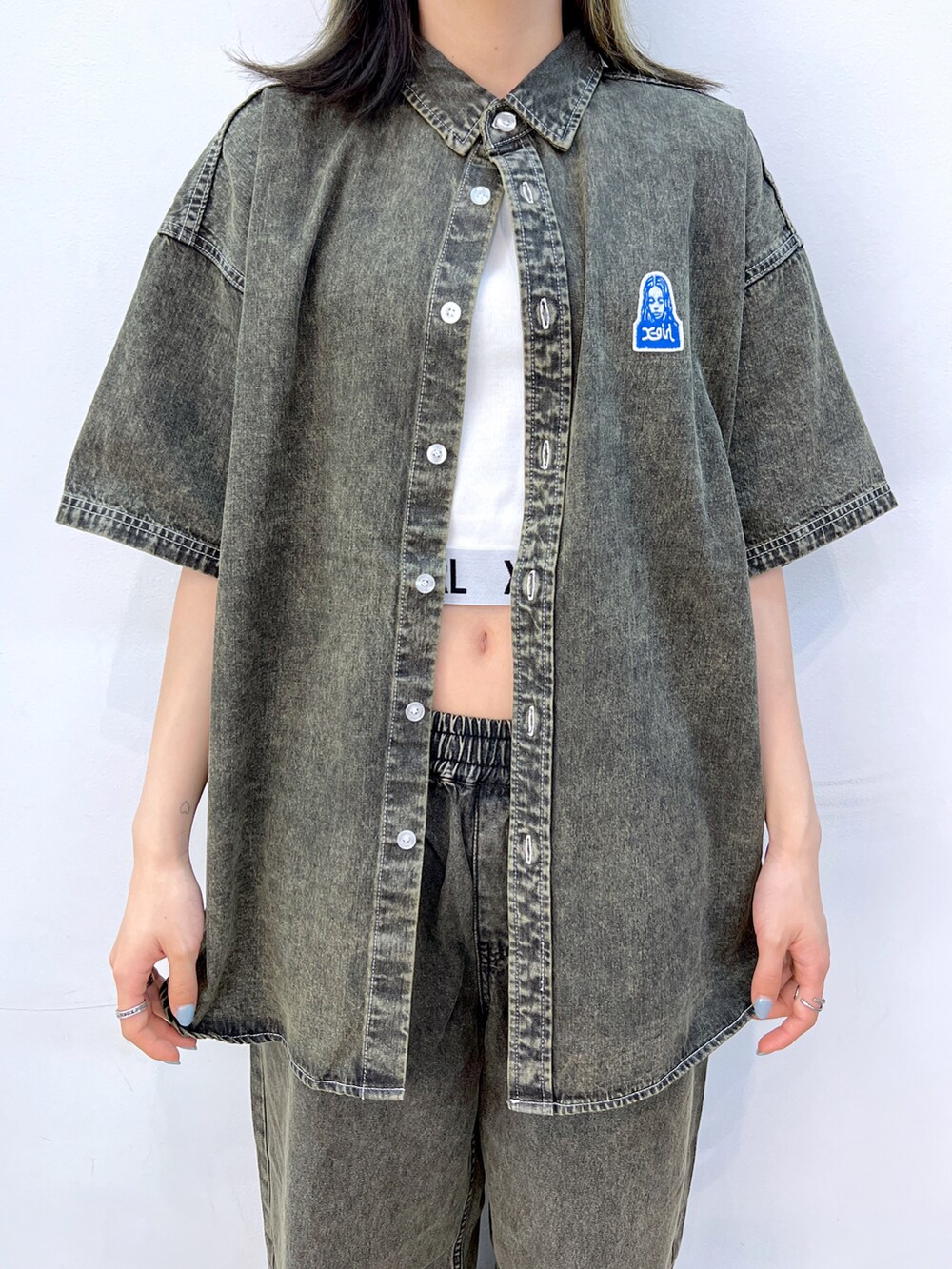 ブラック系のデニムパンツ、ブラック系のシャツ/ブラウス、ホワイト系のTシャツ/カットソーを着用したレディースの夏コーディネートの4枚目の写真