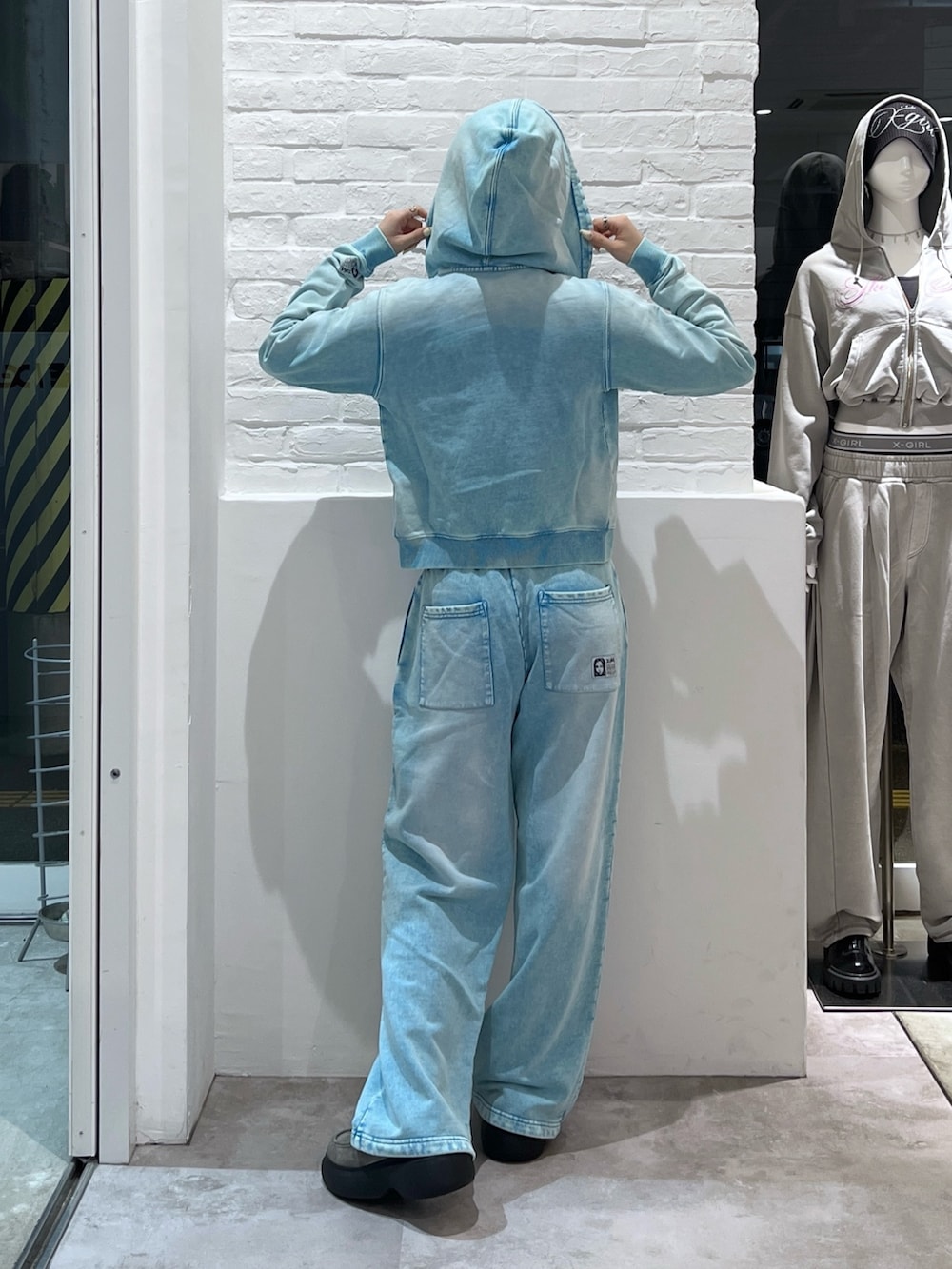 ブルー系のスウェットパンツ、ブルー系のパーカー、グレー系のTシャツ/カットソーを着用したレディースの春コーディネートの2枚目の写真