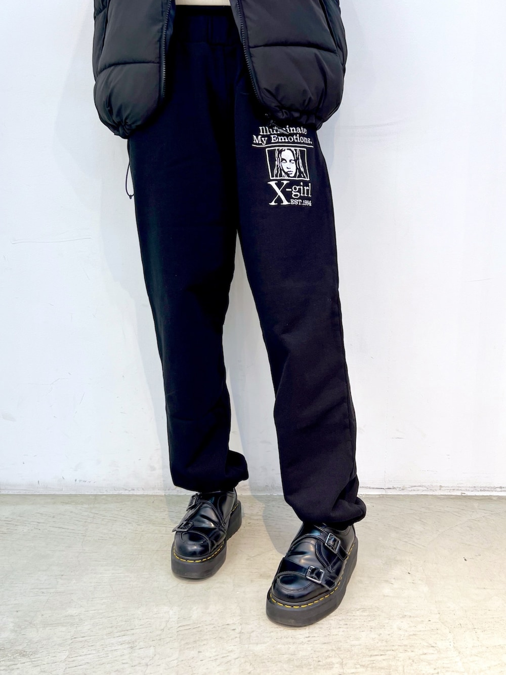 ブラック系のスウェットパンツ、ブラック系のダウンベスト、ホワイト系のTシャツ/カットソーを着用したレディースの秋コーディネートの4枚目の写真