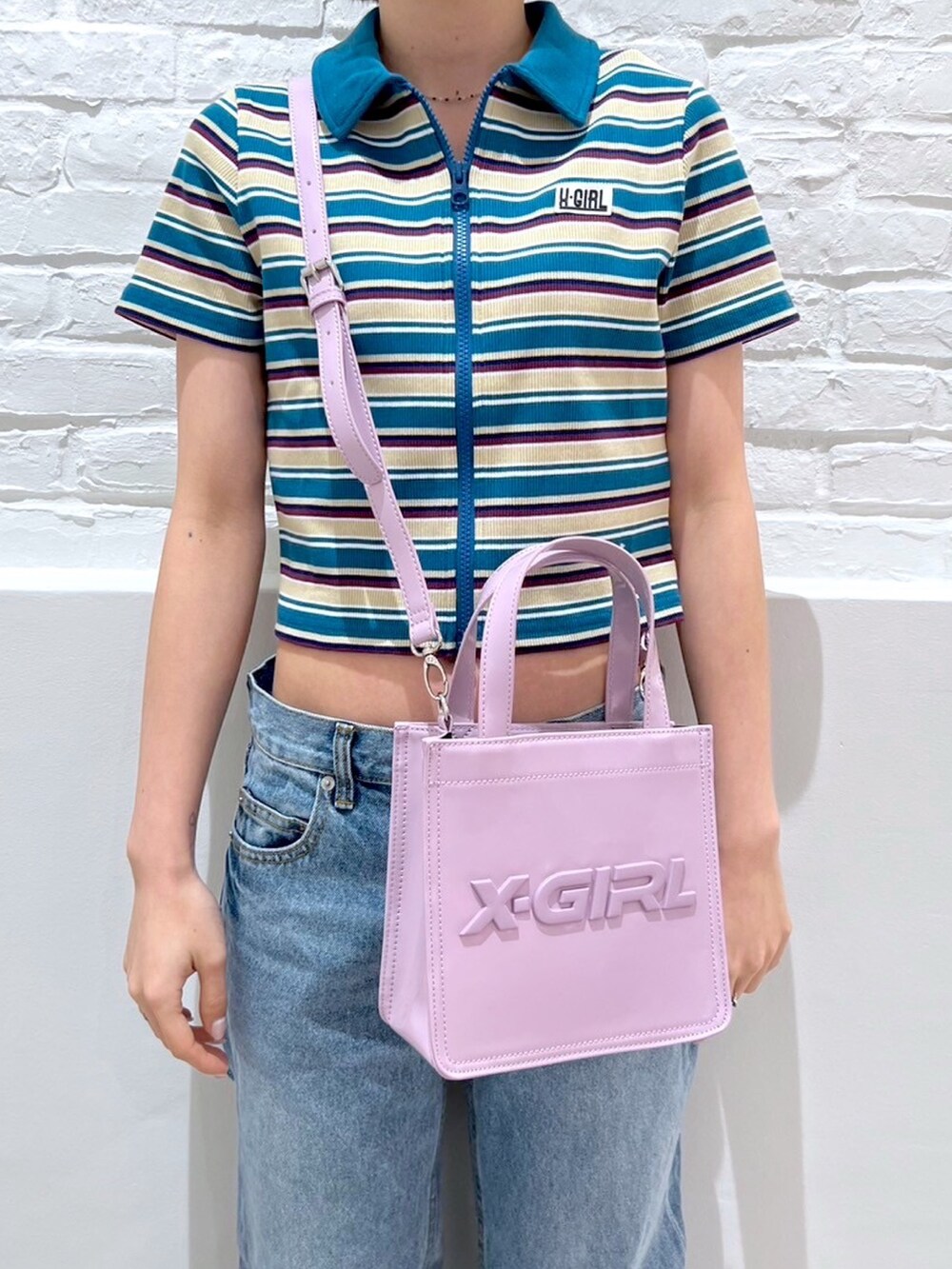 ブルー系のデニムパンツ、ブルー系のシャツ/ブラウス、ピンク系のショルダーバッグを着用したレディースの春コーディネートの3枚目の写真