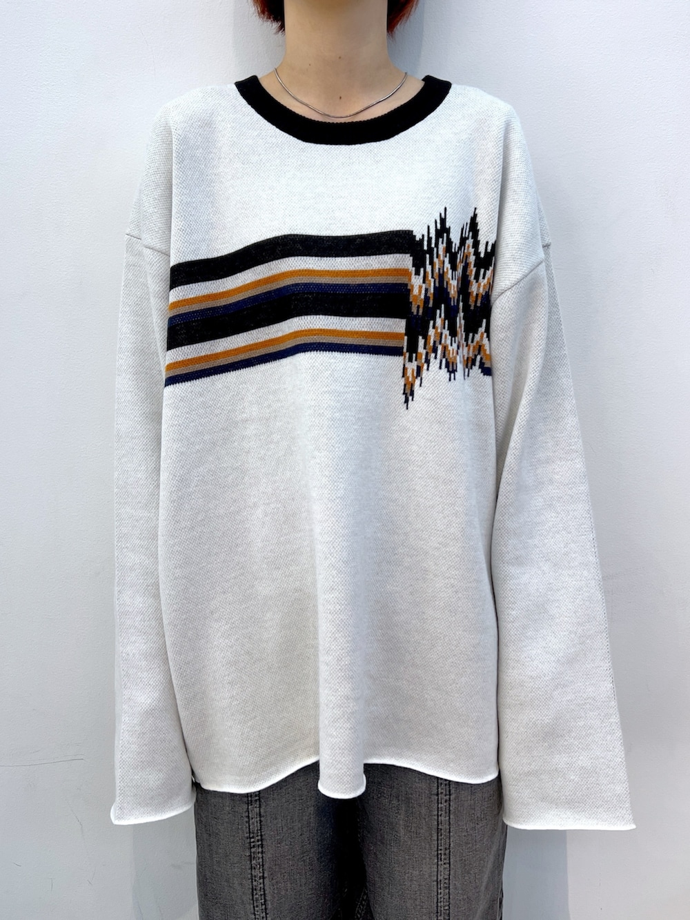 ブラック系のデニムパンツ、ホワイト系のニット/セーター、ブラック系のブルゾンを着用したレディースの冬コーディネートの6枚目の写真