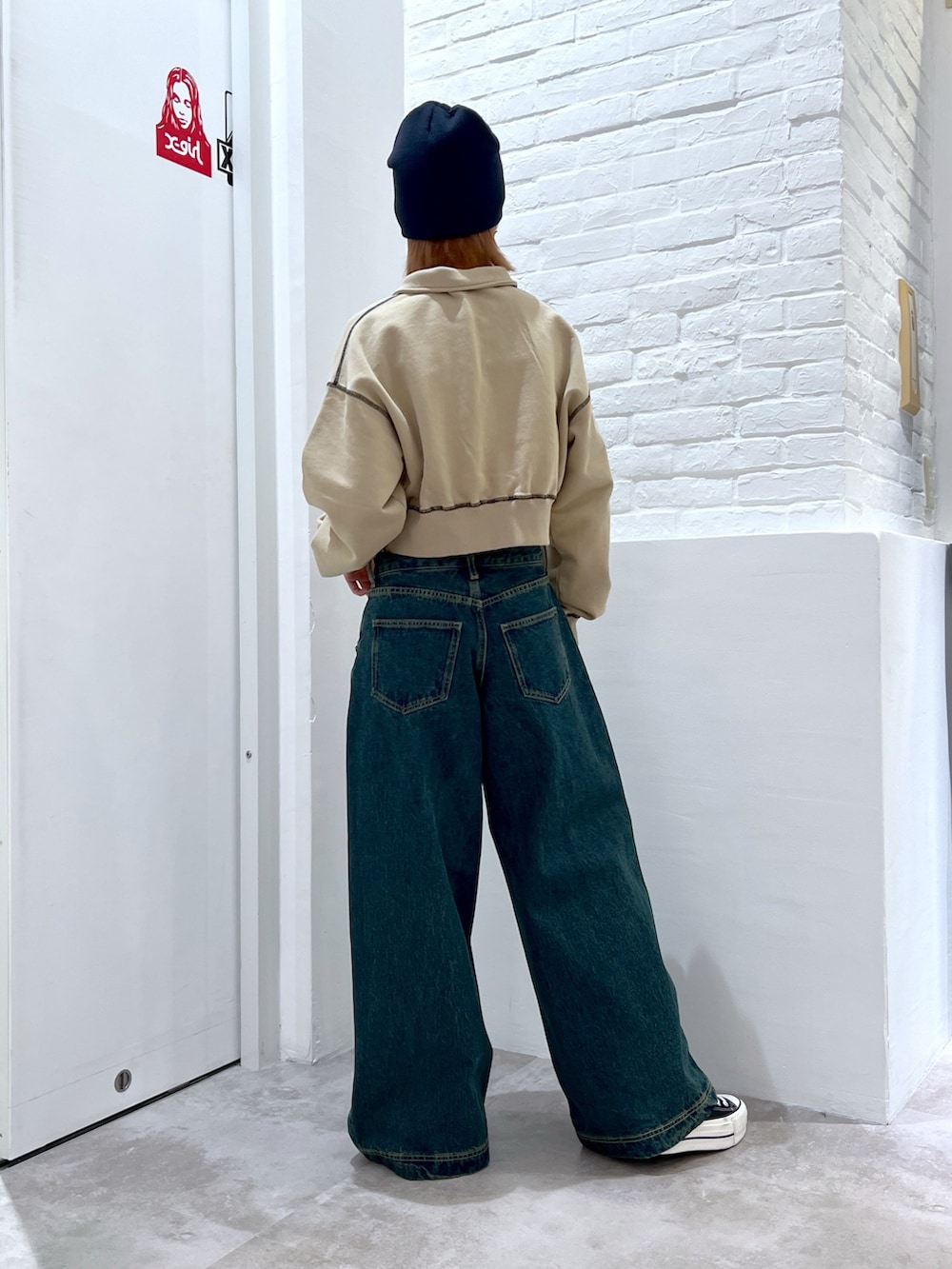 ブルー系のデニムパンツ、ベージュ系のスウェット、ブルー系のニットキャップ/ビーニーを着用したレディースの春コーディネートの2枚目の写真