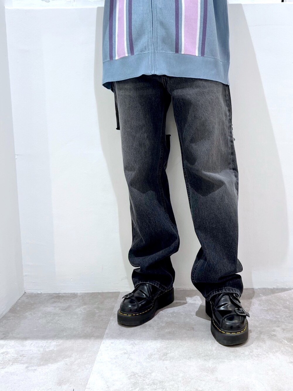 ブラック系のデニムパンツ、ブルー系のポロシャツ、ブラック系のニットキャップ/ビーニーを着用したレディースの春コーディネートの4枚目の写真