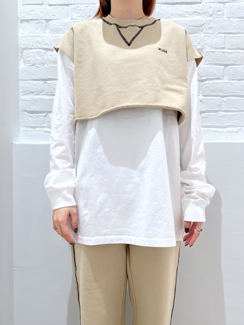 ベージュ系のスウェットパンツ、ホワイト系のTシャツ/カットソー、ベージュ系のベストを着用したレディースの春コーディネートの3枚目の写真
