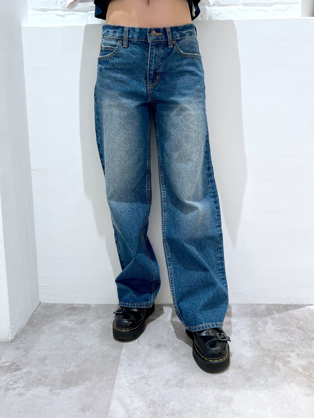 ブルー系のデニムパンツ、ブラック系のハンドバッグ、ブルー系のTシャツ/カットソーを着用したレディースの春コーディネートの4枚目の写真