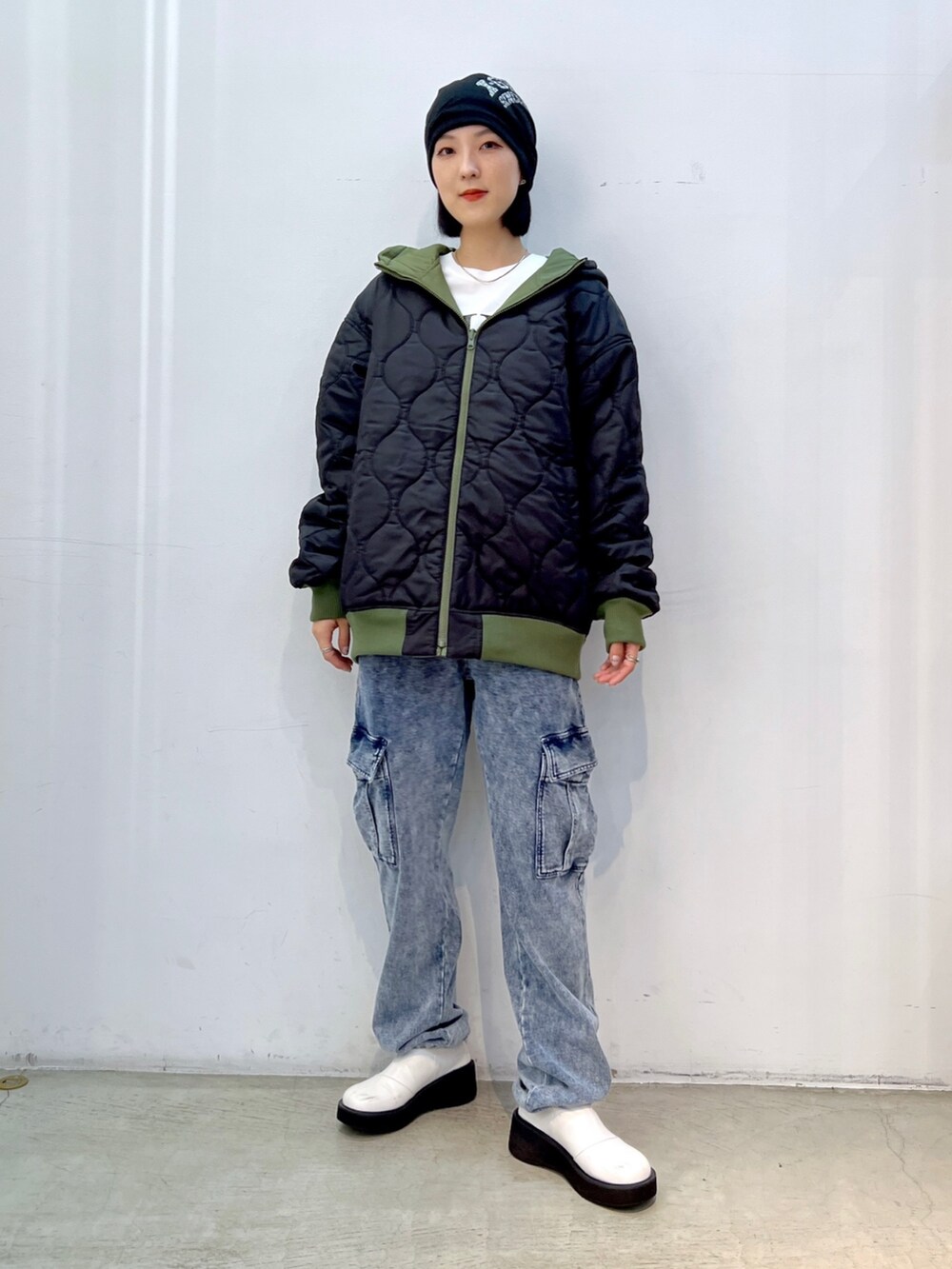ブルー系のスウェットパンツ、グリーン系のナイロンジャケット、ホワイト系のTシャツ/カットソーを着用したレディースの秋コーディネートの3枚目の写真