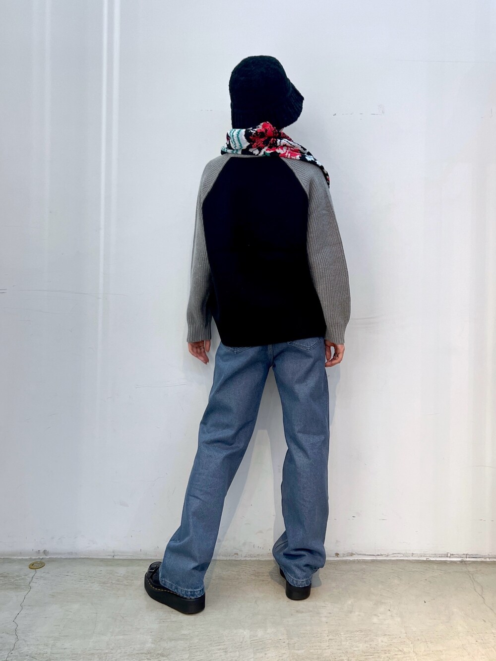 ブルー系のデニムパンツ、ブラック系のニット/セーター、ブラック系のニットキャップ/ビーニーを着用したレディースの秋コーディネートの2枚目の写真