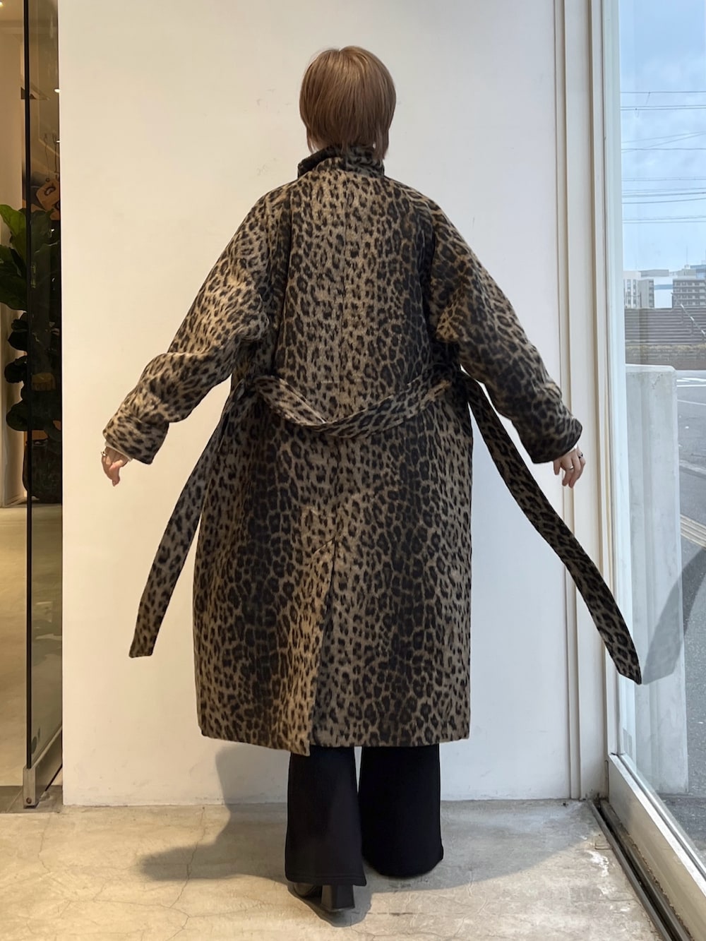 ブラック系のスウェットパンツ、ホワイト系のニット/セーター、ベージュ系のステンカラーコートを着用したレディースの秋コーディネートの2枚目の写真