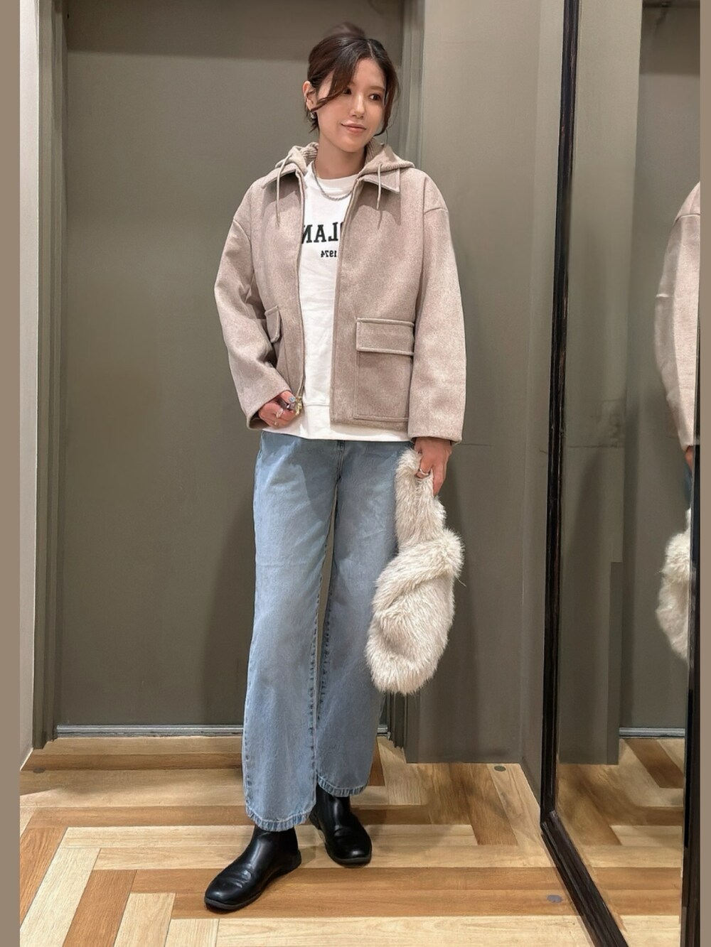 ベージュ系のその他アウター、グレー系のエコバッグ/サブバッグ、ブルー系のデニムパンツを着用したレディースの秋コーディネートの3枚目の写真