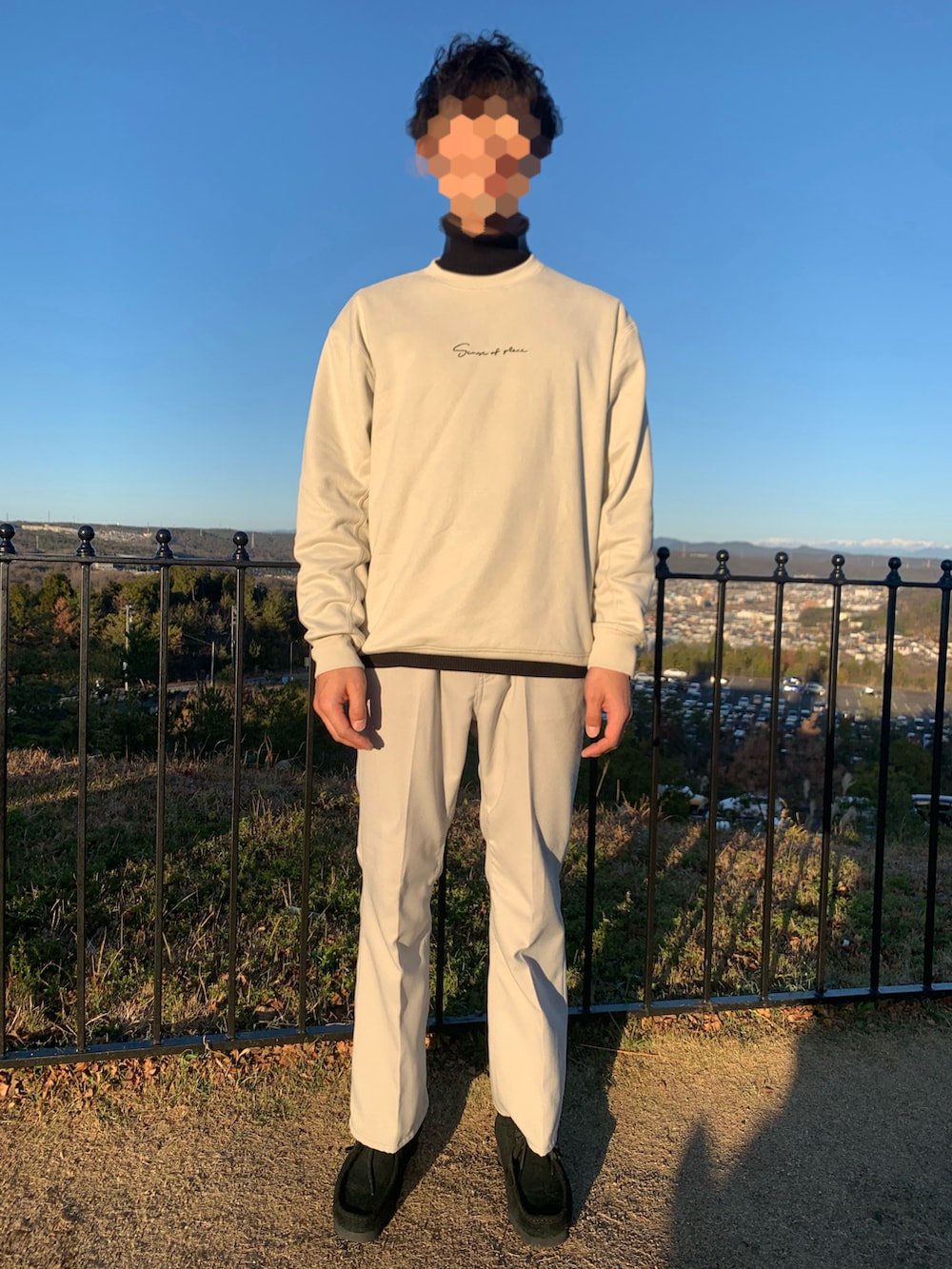 ブラック系のブーツ、グレー系のスラックス、ブラック系のステンカラーコートを着用したメンズの冬コーディネートの2枚目の写真