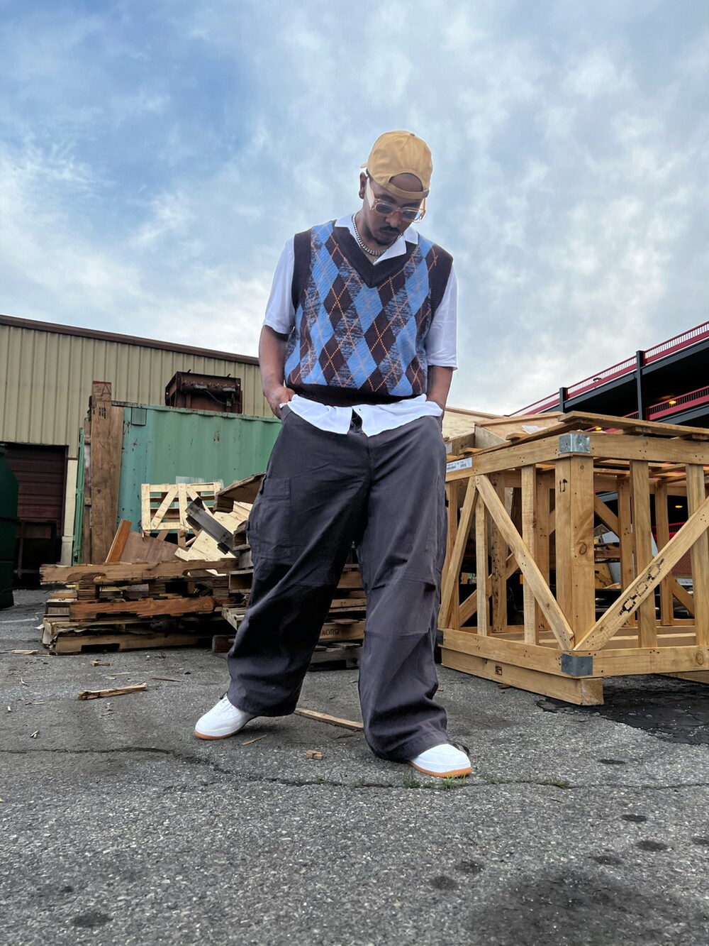 ブルー系のニット/セーター、ホワイト系のシャツ/ブラウス、グレー系のカーゴパンツを着用したメンズの夏コーディネートの2枚目の写真