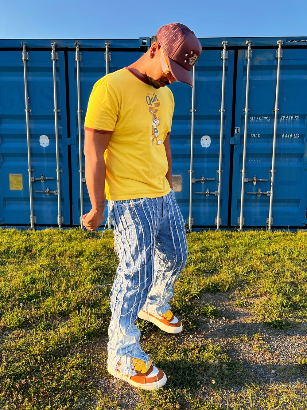 イエロー系のTシャツ/カットソー、ブルー系のデニムパンツ、ブラウン系のスニーカーを着用したメンズの夏コーディネートの3枚目の写真