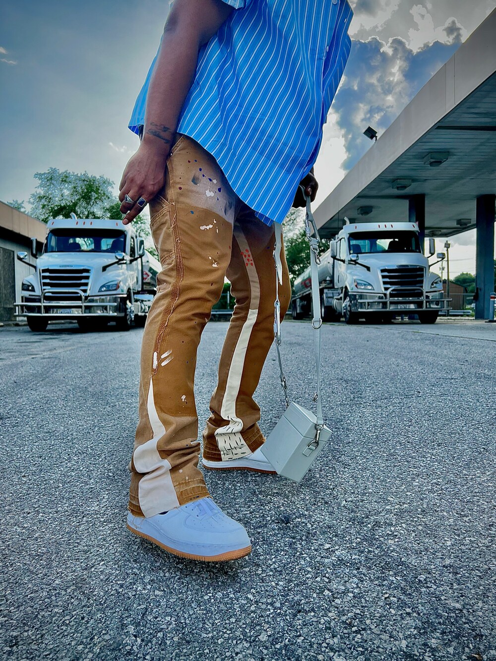 ブルー系のシャツ/ブラウス、ブラウン系のチノパンツ、ホワイト系のスニーカーを着用したメンズの夏コーディネートの3枚目の写真