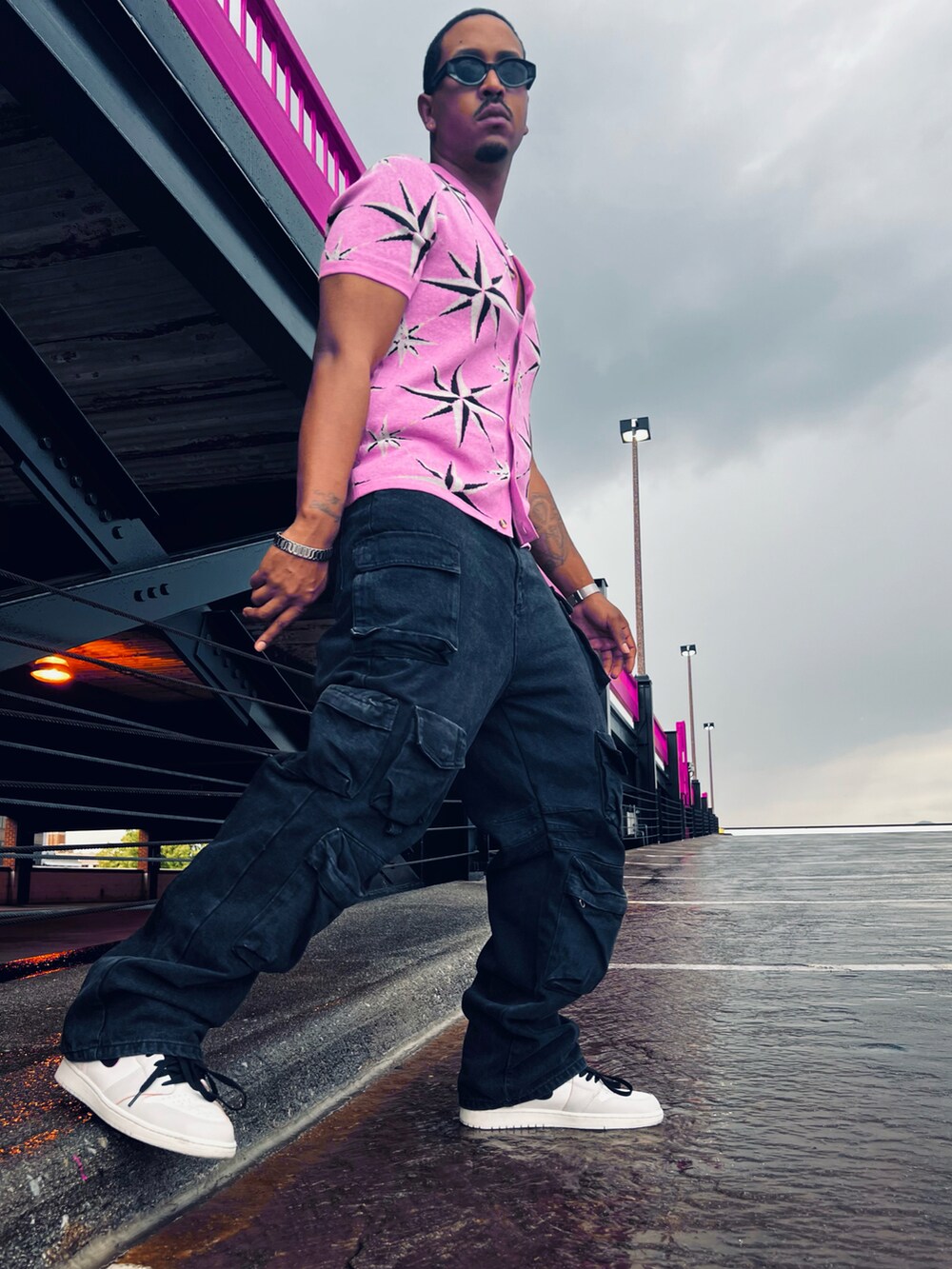 ピンク系のシャツ/ブラウス、ブラック系のカーゴパンツ、ホワイト系のスニーカーを着用したメンズの夏コーディネートの2枚目の写真