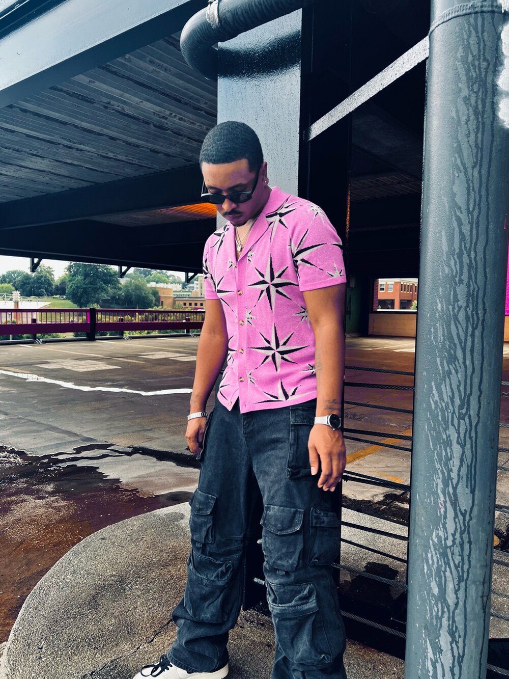 ピンク系のシャツ/ブラウス、ブラック系のカーゴパンツ、ホワイト系のスニーカーを着用したメンズの夏コーディネートの3枚目の写真