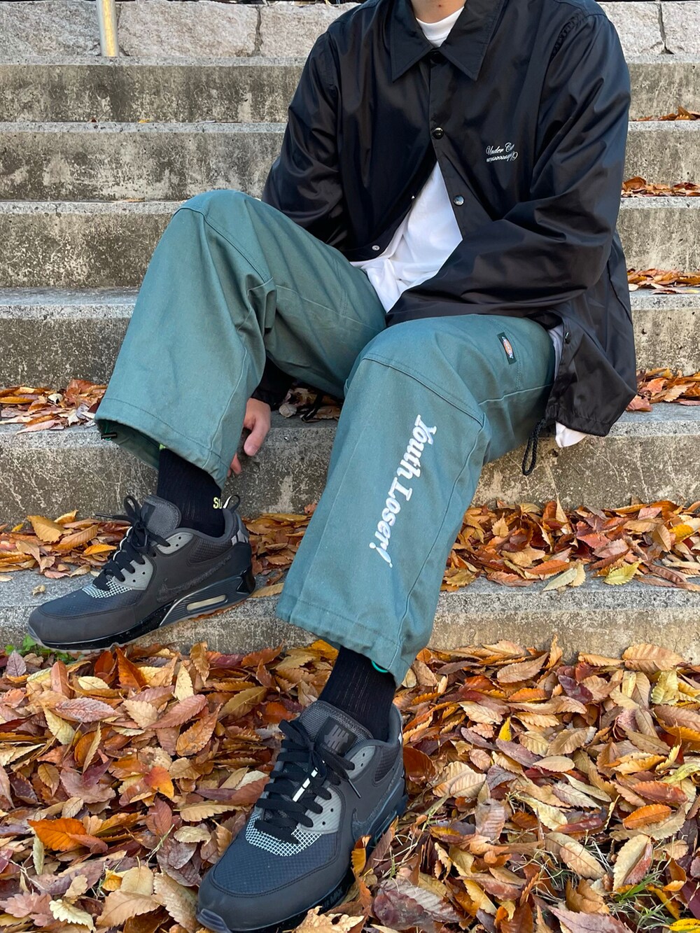 ブラック系のカバーオール、グリーン系のパンツ、イエロー系のその他を着用したメンズの秋コーディネートの2枚目の写真