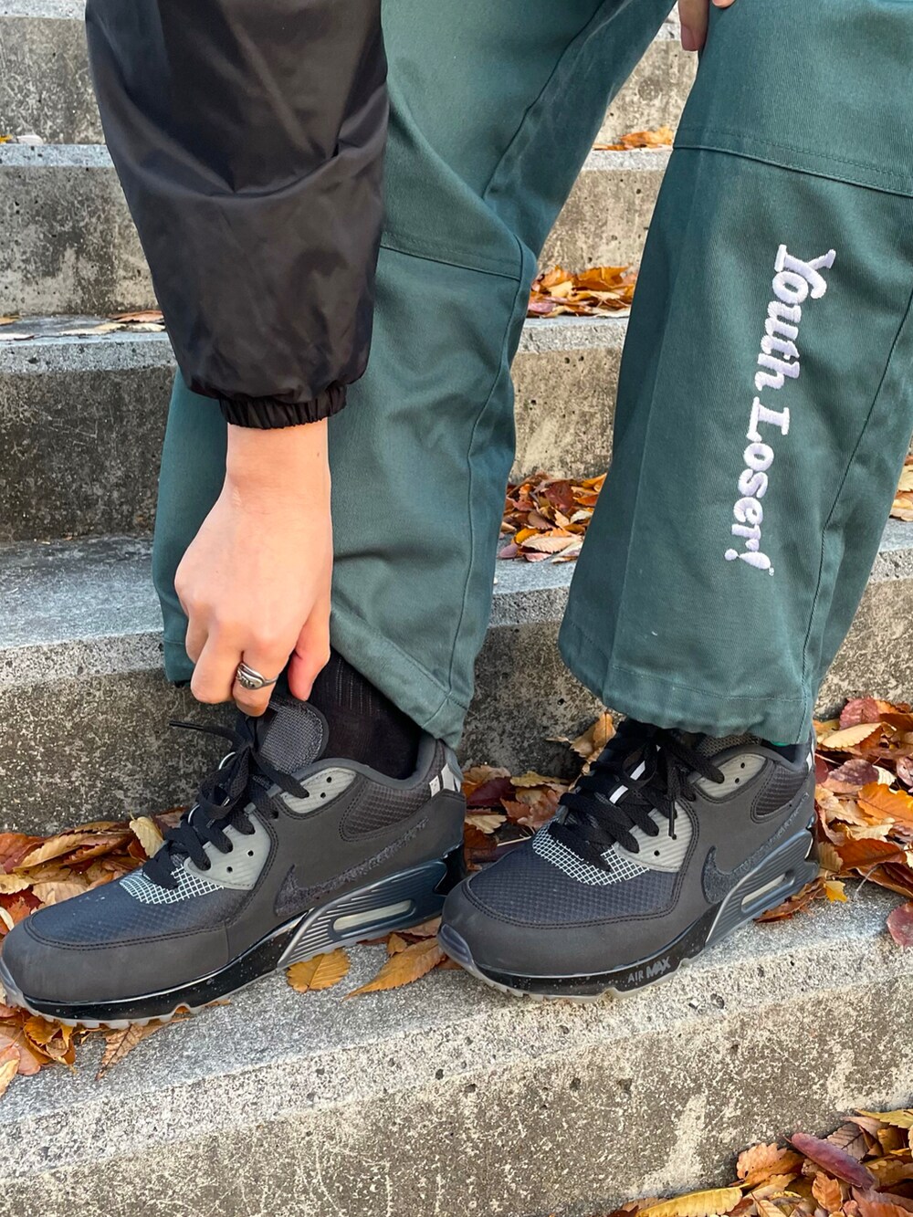 ブラック系のカバーオール、グリーン系のパンツ、イエロー系のその他を着用したメンズの秋コーディネートの5枚目の写真