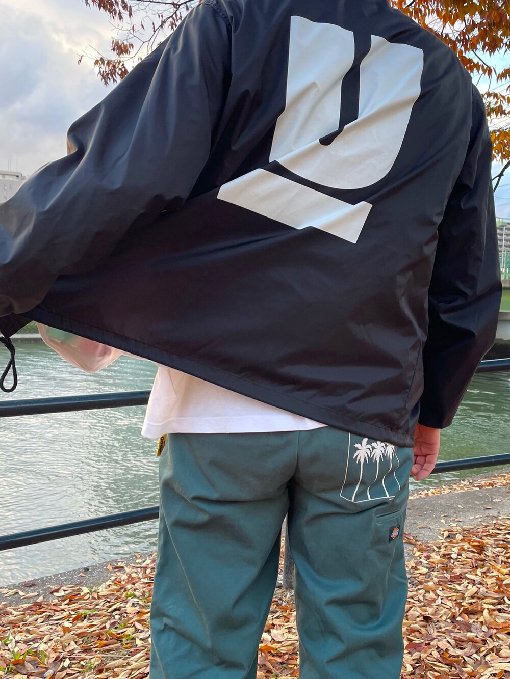 ブラック系のカバーオール、グリーン系のパンツ、イエロー系のその他を着用したメンズの秋コーディネートの4枚目の写真