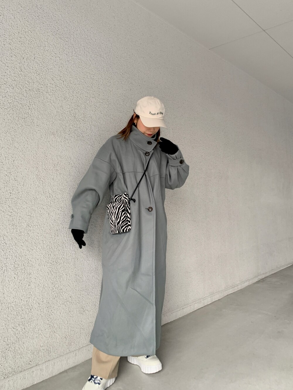 ホワイト系のショルダーバッグ、ブルー系のその他アウター、ホワイト系のスニーカーを着用したレディースの冬コーディネートの2枚目の写真