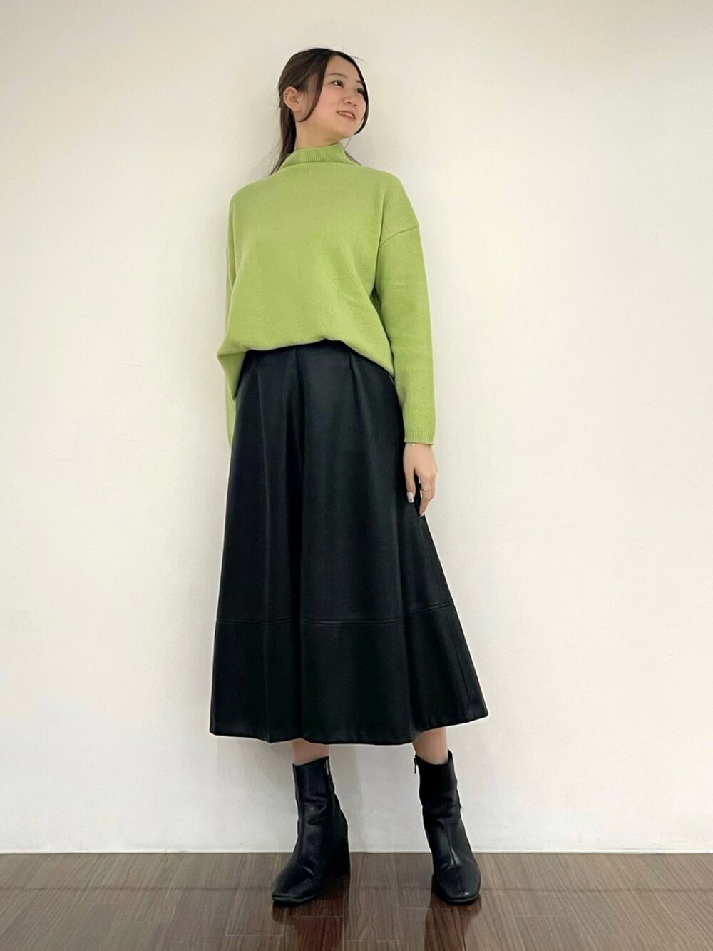 グリーン系のニット/セーター、ブラック系のスカート、その他のその他を着用したレディースの秋コーディネートの2枚目の写真