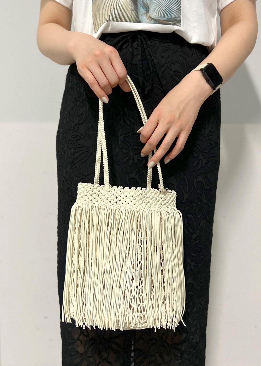 ブラック系のサンダル、ホワイト系のTシャツ/カットソー、ホワイト系のトートバッグを着用したレディースの春コーディネートの7枚目の写真