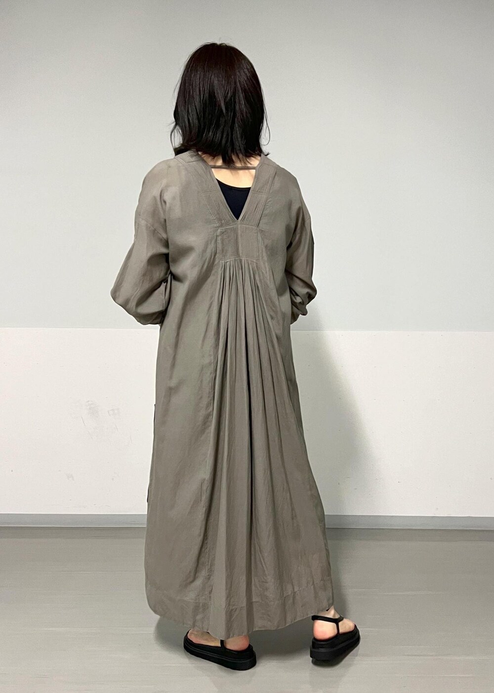 ブラック系のサンダル、グレー系のワンピース、ブラック系のかごバッグを着用したレディースの春コーディネートの2枚目の写真