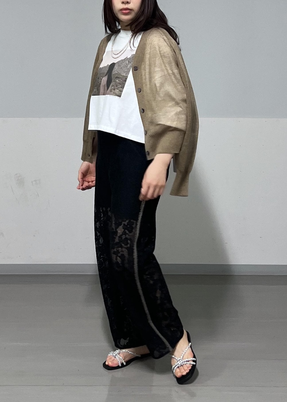 シルバー系のショルダーバッグ、ゴールド系のサンダル、ゴールド系のカーディガン/ボレロを着用したレディースの春コーディネートの3枚目の写真