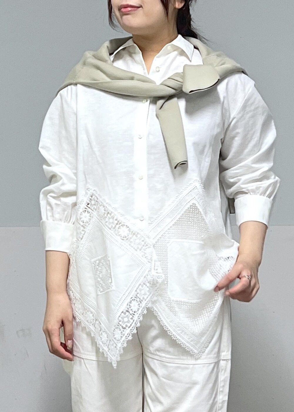 ブルー系のトートバッグ、ホワイト系のシャツ/ブラウス、ベージュ系のニット/セーターを着用したレディースの冬コーディネートの5枚目の写真