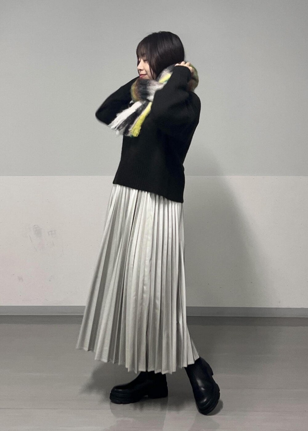 ブラック系のブーツ、ブラウン系のニット/セーター、シルバー系のスカートを着用したレディースの秋コーディネートの4枚目の写真