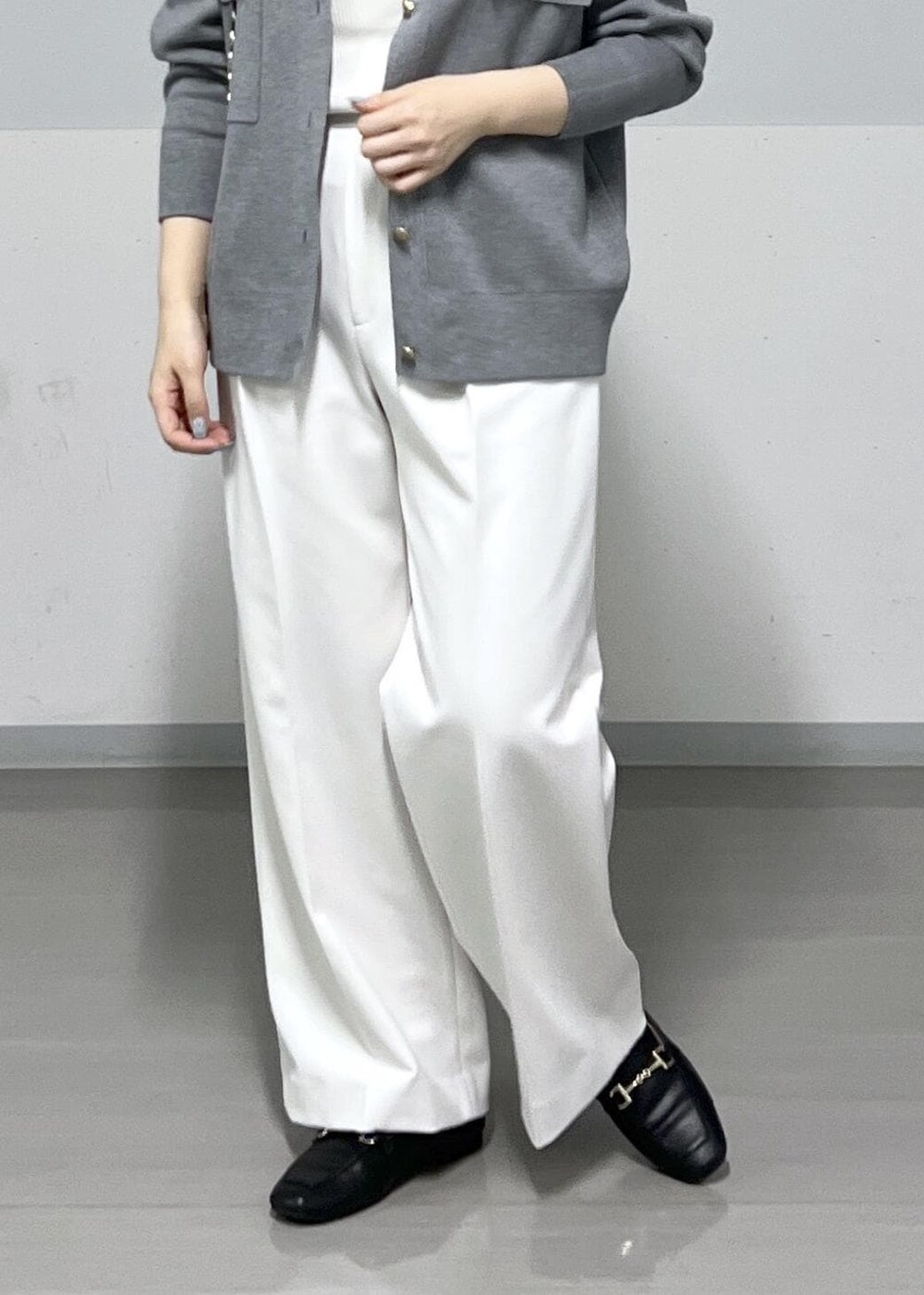 ブラック系のショルダーバッグ、ホワイト系のその他パンツ、グレー系のカーディガン/ボレロを着用したレディースの冬コーディネートの6枚目の写真
