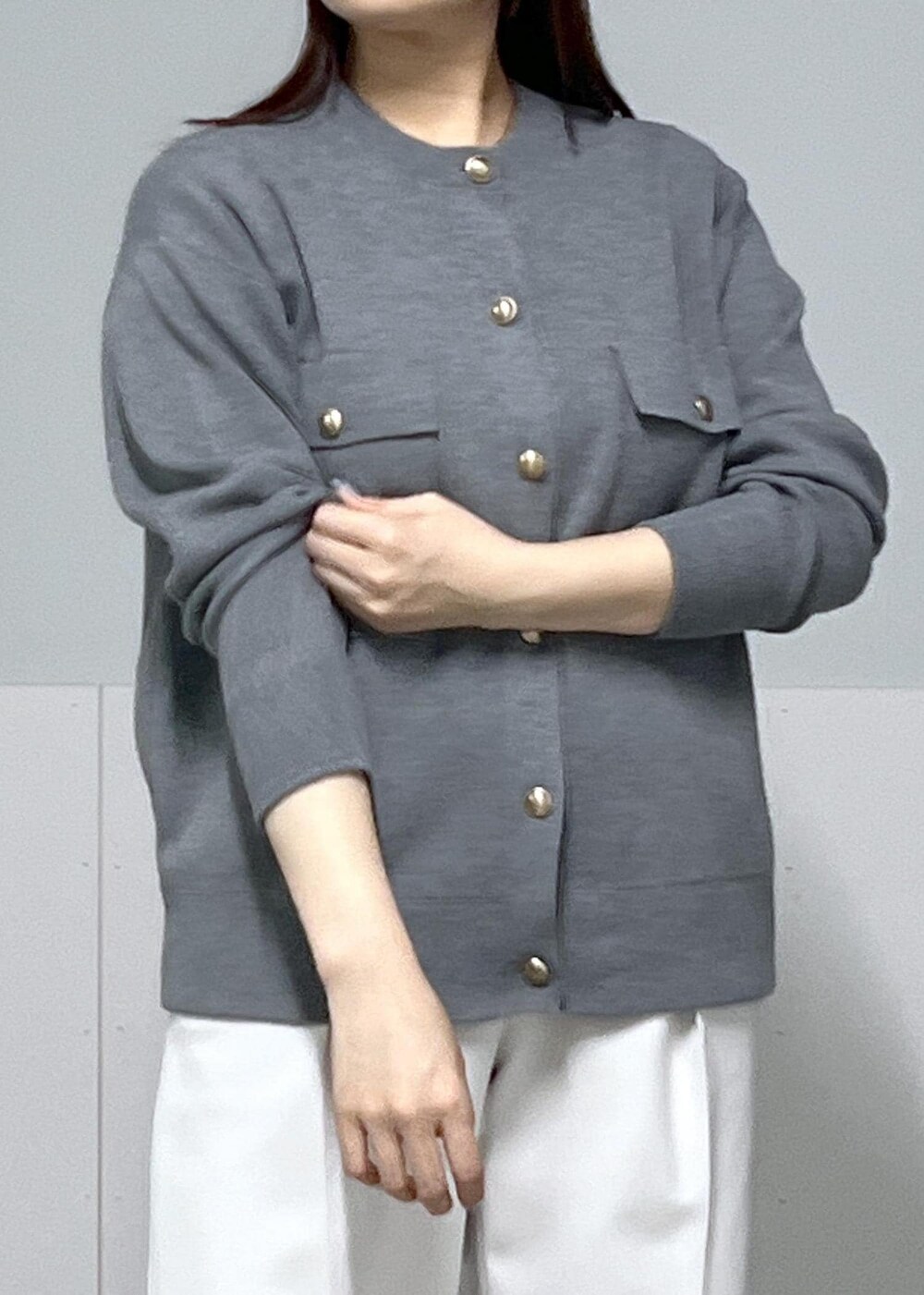 ブラック系のショルダーバッグ、ホワイト系のその他パンツ、グレー系のカーディガン/ボレロを着用したレディースの冬コーディネートの3枚目の写真