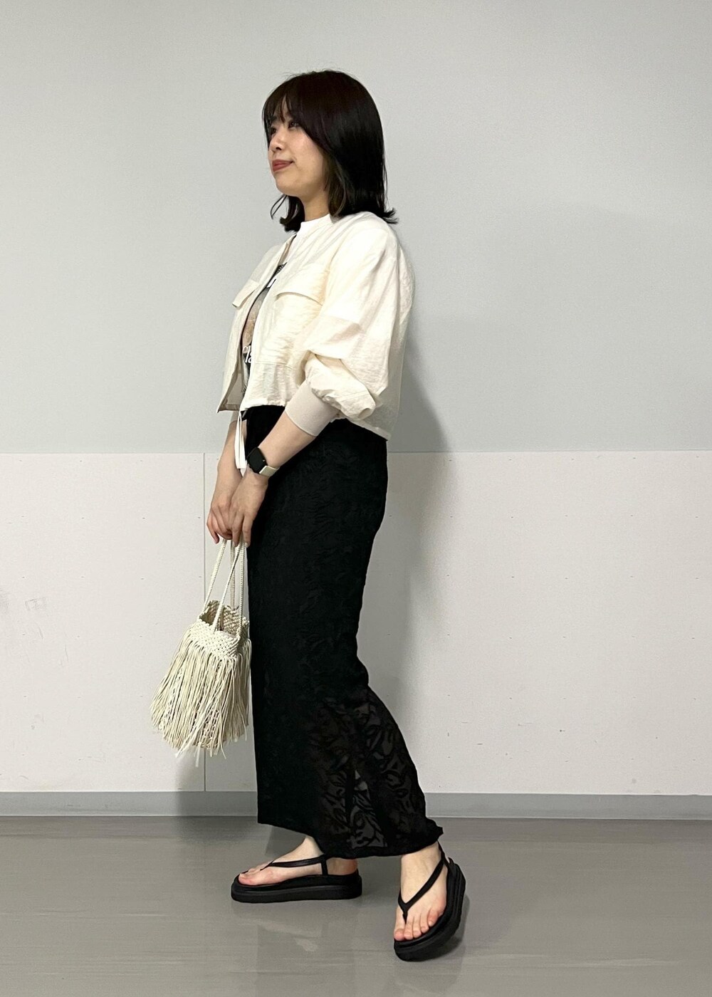 ブラック系のサンダル、ホワイト系のTシャツ/カットソー、ホワイト系のトートバッグを着用したレディースの春コーディネートの2枚目の写真