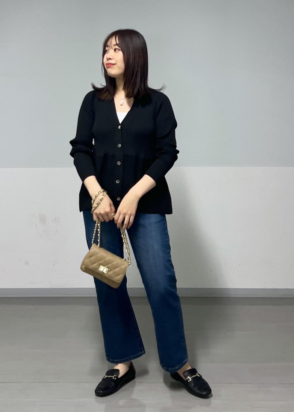 ベージュ系のショルダーバッグ、ブラック系のカーディガン/ボレロを着用したレディースの秋コーディネートの2枚目の写真