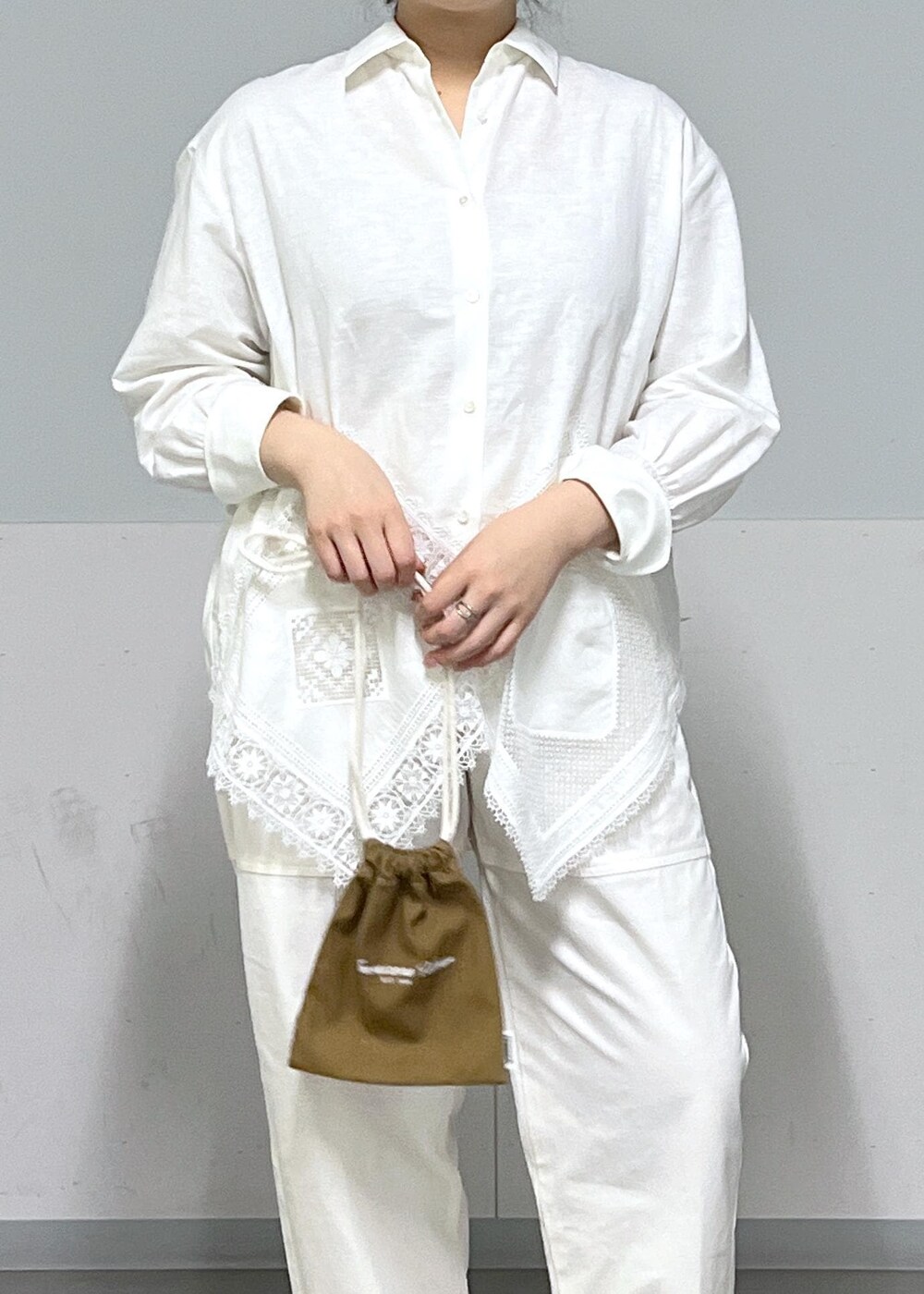 ブルー系のトートバッグ、ホワイト系のシャツ/ブラウス、ベージュ系のニット/セーターを着用したレディースの冬コーディネートの10枚目の写真