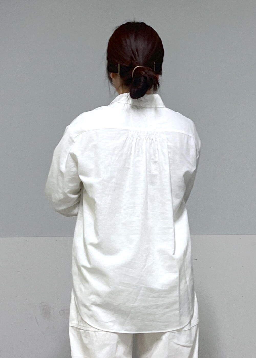 ブルー系のトートバッグ、ホワイト系のシャツ/ブラウス、ベージュ系のニット/セーターを着用したレディースの冬コーディネートの7枚目の写真