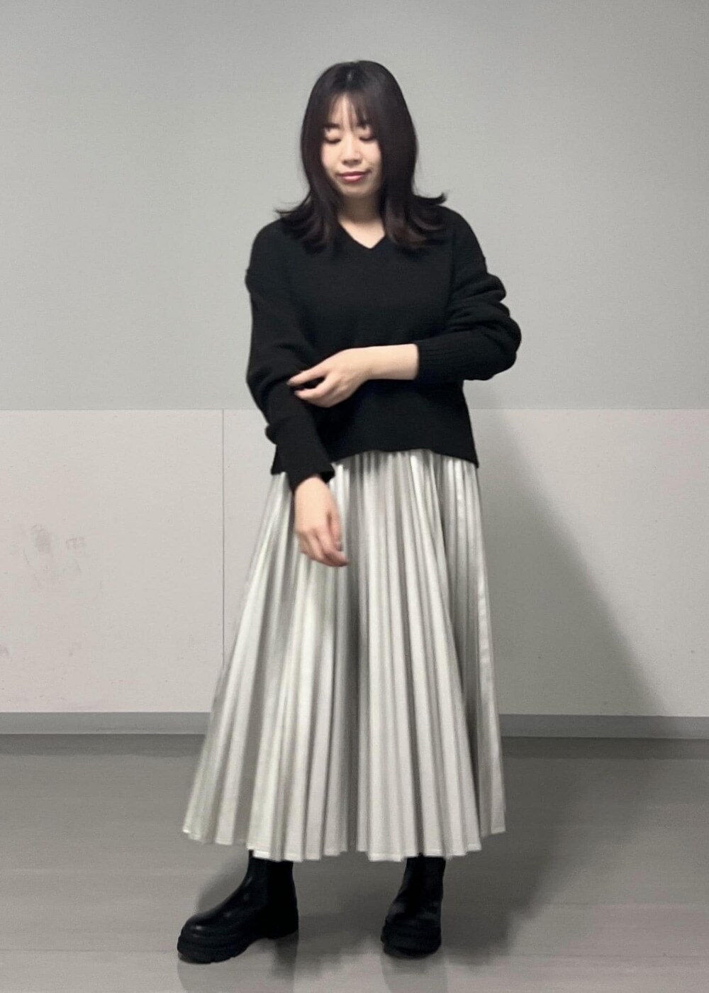 ブラック系のブーツ、ブラウン系のニット/セーター、シルバー系のスカートを着用したレディースの秋コーディネートの6枚目の写真