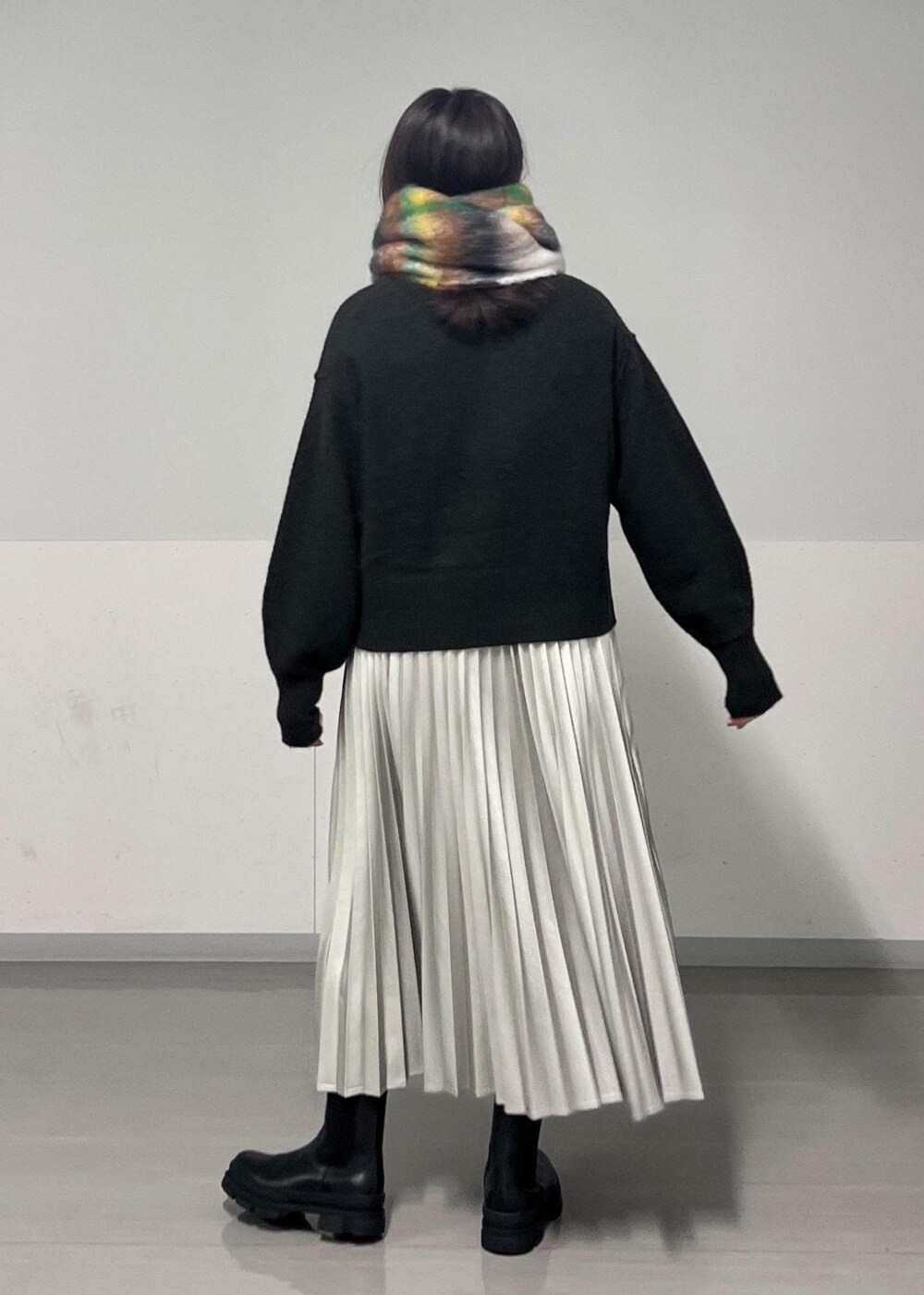 ブラック系のブーツ、ブラウン系のニット/セーター、シルバー系のスカートを着用したレディースの秋コーディネートの5枚目の写真