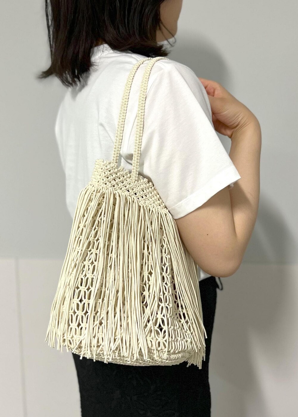 ブラック系のサンダル、ホワイト系のTシャツ/カットソー、ホワイト系のトートバッグを着用したレディースの春コーディネートの8枚目の写真