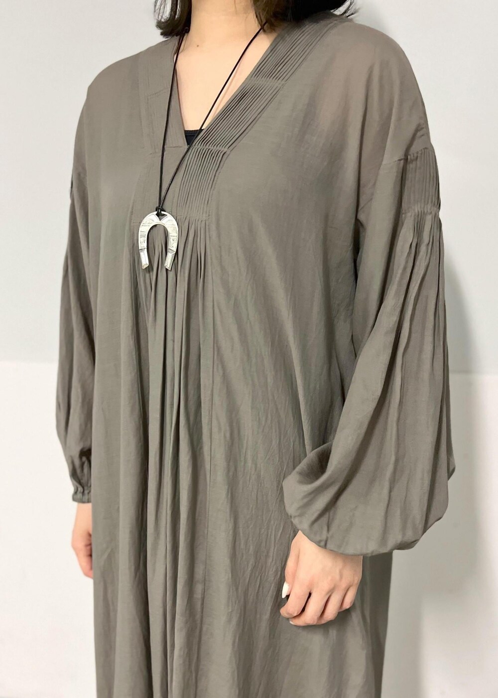 ブラック系のサンダル、グレー系のワンピース、ブラック系のかごバッグを着用したレディースの春コーディネートの5枚目の写真