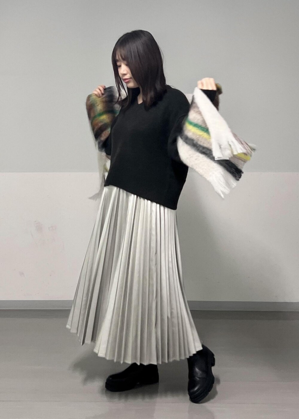 ブラック系のブーツ、ブラウン系のニット/セーター、シルバー系のスカートを着用したレディースの秋コーディネートの3枚目の写真