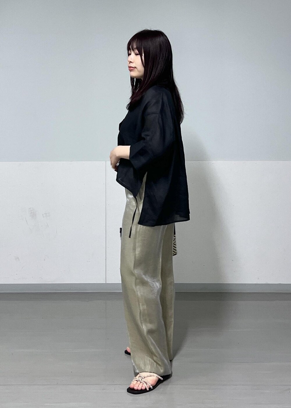 ブラック系のかごバッグ、ゴールド系のサンダル、グレー系のその他パンツを着用したレディースの春コーディネートの2枚目の写真