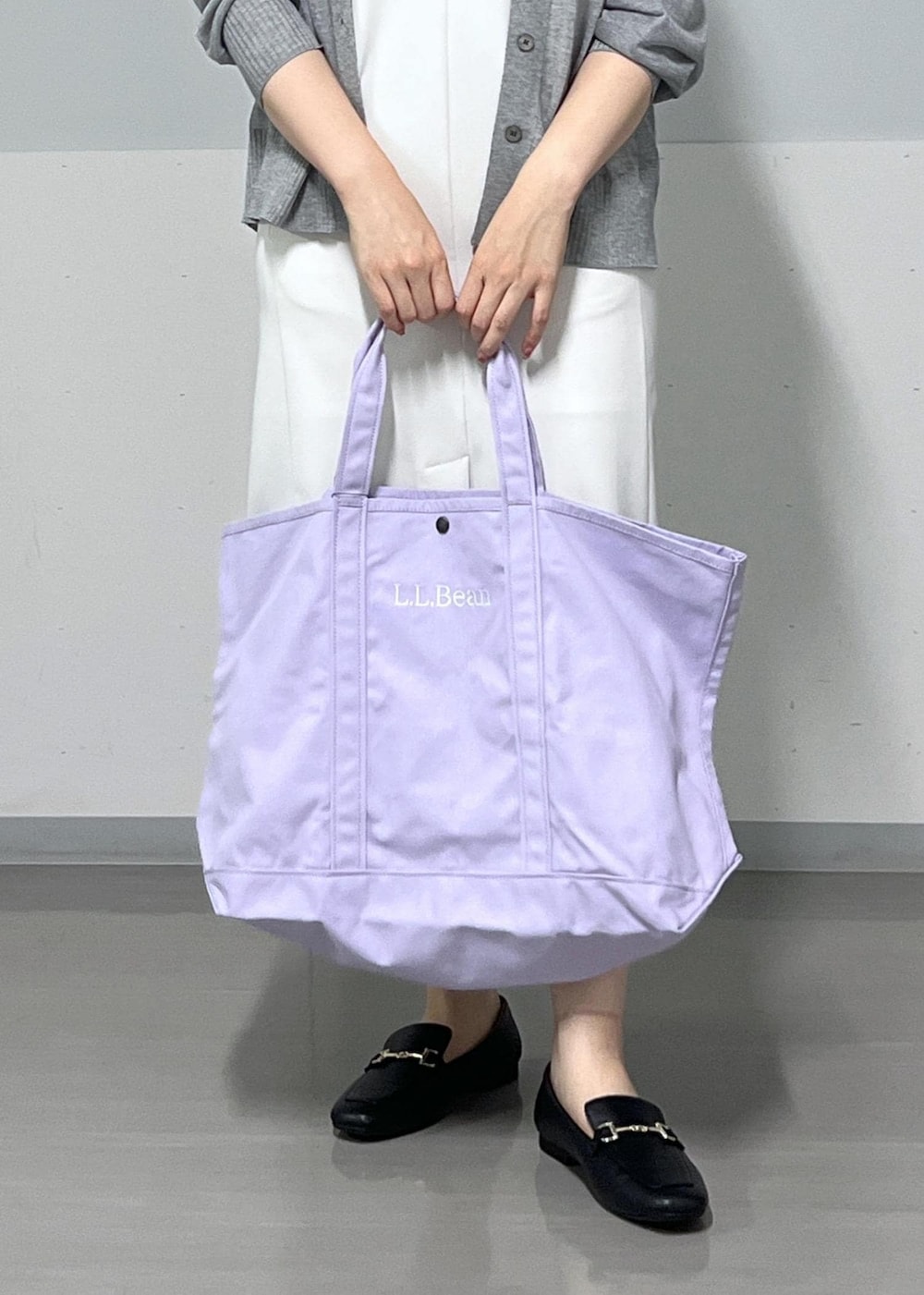 シルバー系のカーディガン/ボレロ、ホワイト系のジャンパースカート、パープル系のトートバッグを着用したレディースの夏コーディネートの7枚目の写真