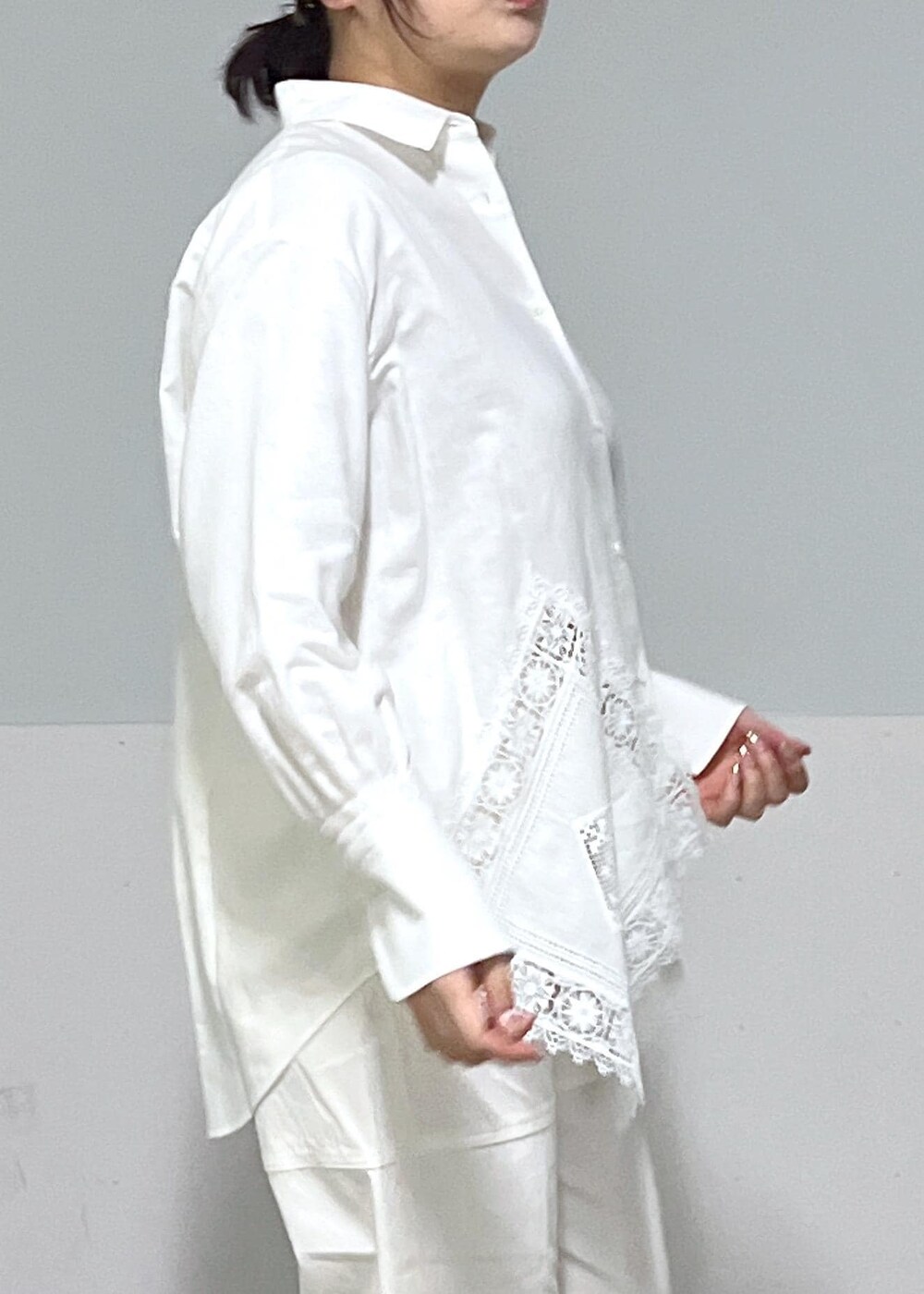 ブルー系のトートバッグ、ホワイト系のシャツ/ブラウス、ベージュ系のニット/セーターを着用したレディースの冬コーディネートの6枚目の写真