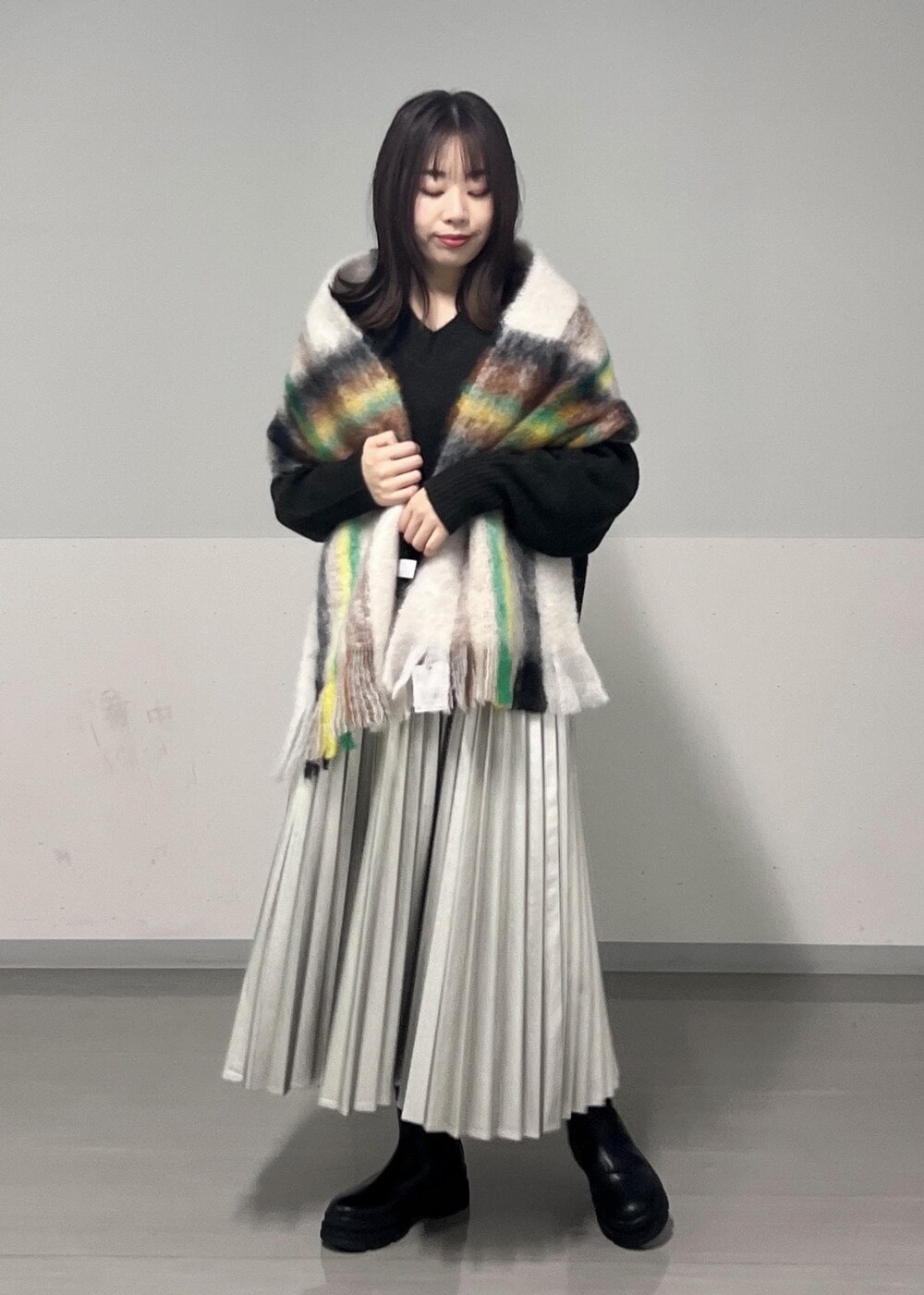 ブラック系のブーツ、ブラウン系のニット/セーター、シルバー系のスカートを着用したレディースの秋コーディネートの2枚目の写真