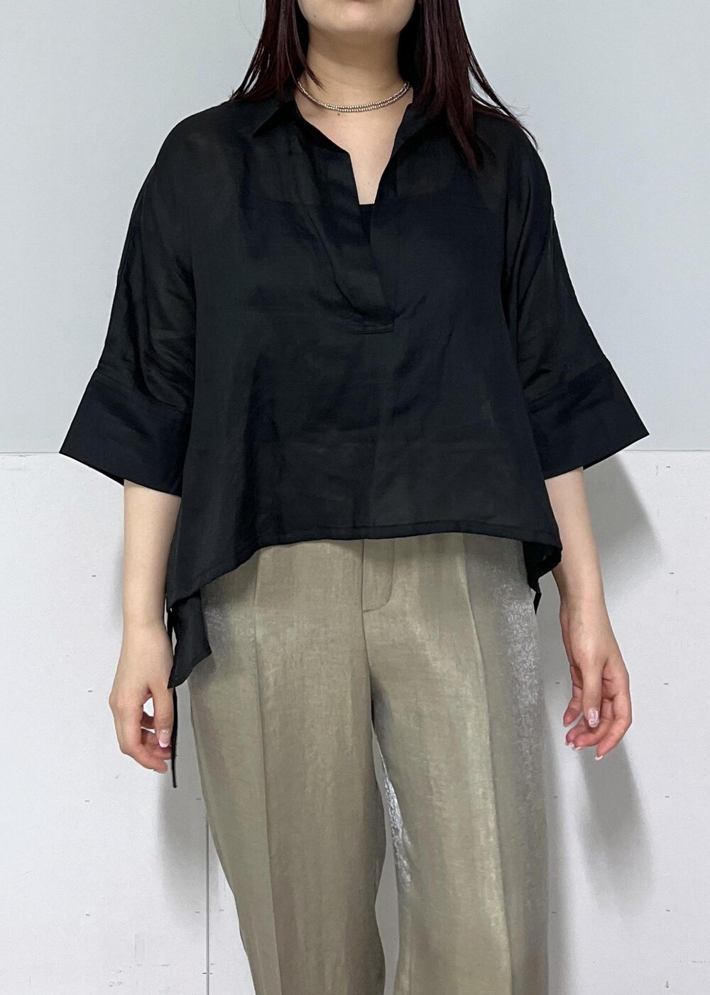 ブラック系のかごバッグ、ゴールド系のサンダル、グレー系のその他パンツを着用したレディースの春コーディネートの4枚目の写真