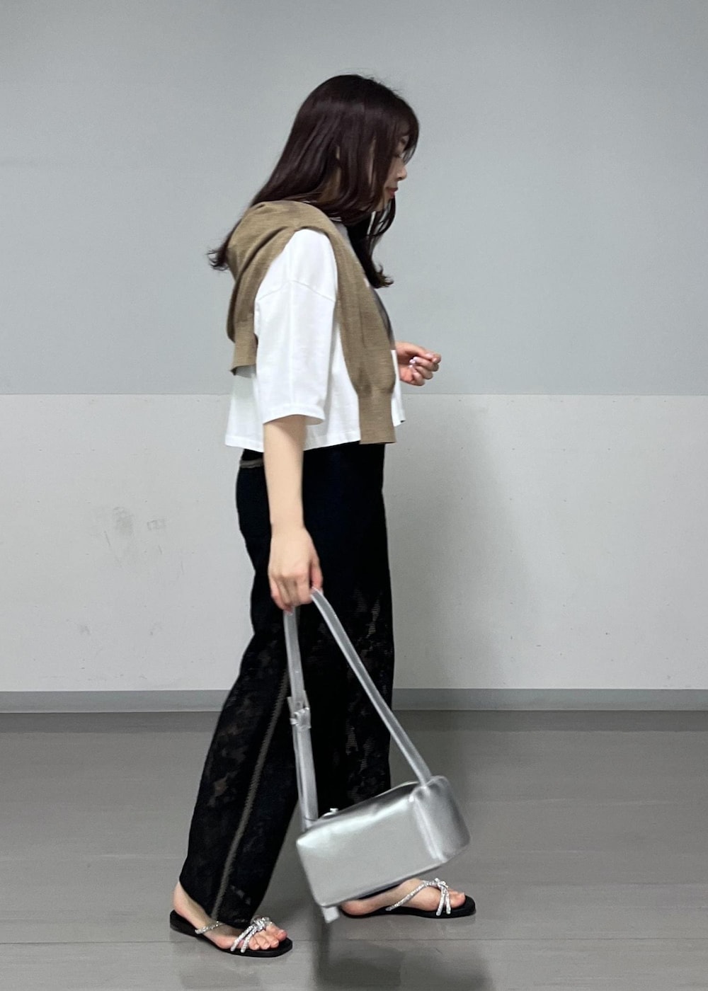 シルバー系のショルダーバッグ、ゴールド系のサンダル、ゴールド系のカーディガン/ボレロを着用したレディースの春コーディネートの2枚目の写真