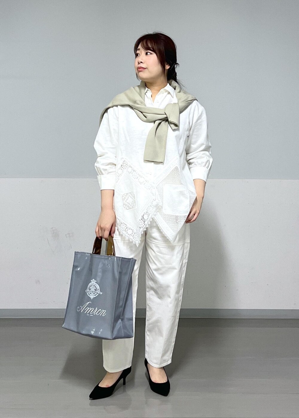 ブルー系のトートバッグ、ホワイト系のシャツ/ブラウス、ベージュ系のニット/セーターを着用したレディースの冬コーディネートの2枚目の写真