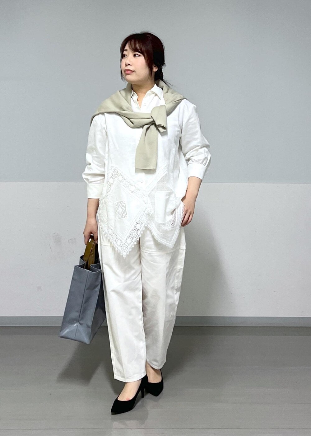 ブルー系のトートバッグ、ホワイト系のシャツ/ブラウス、ベージュ系のニット/セーターを着用したレディースの冬コーディネートの3枚目の写真