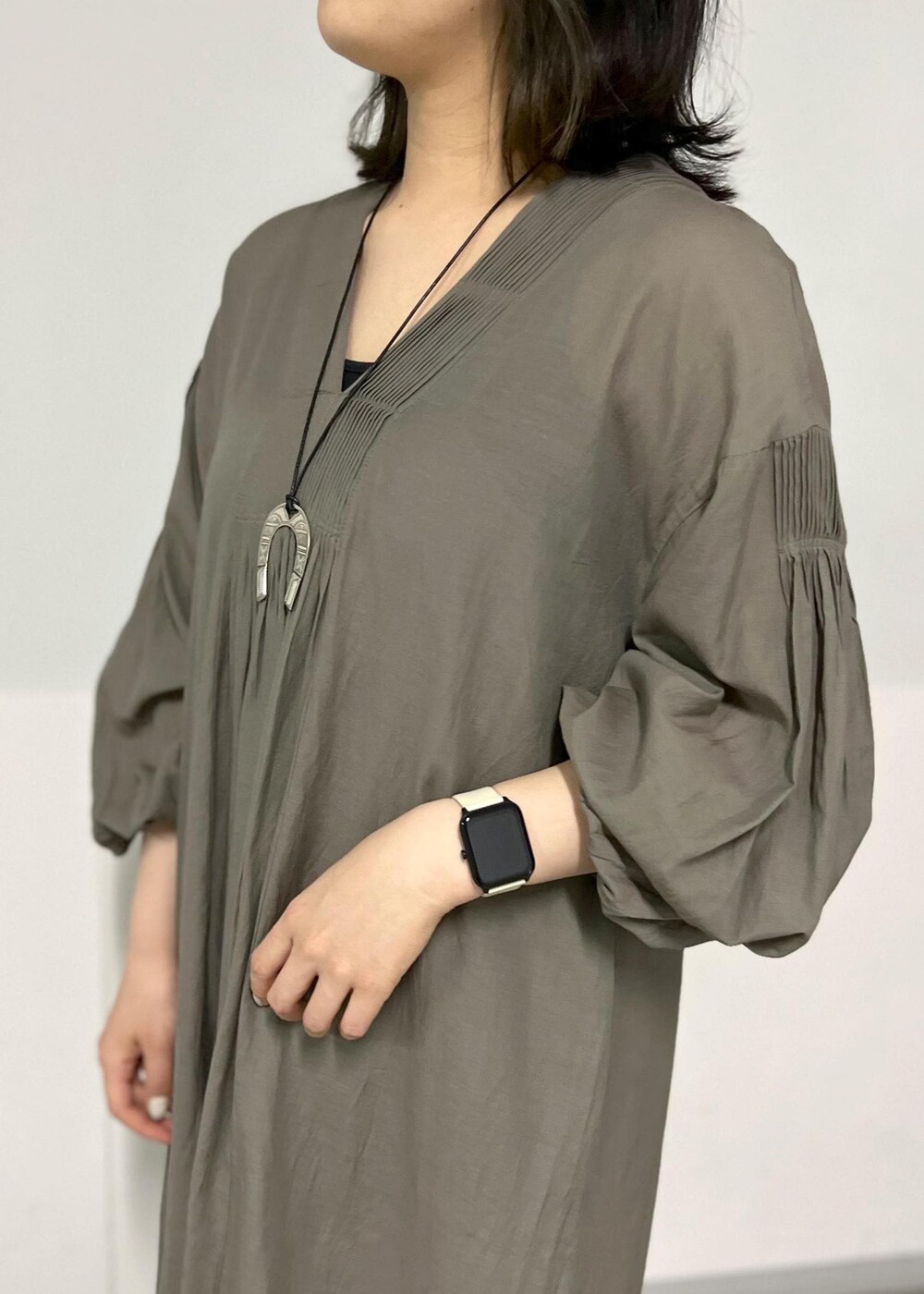 ブラック系のサンダル、グレー系のワンピース、ブラック系のかごバッグを着用したレディースの春コーディネートの4枚目の写真